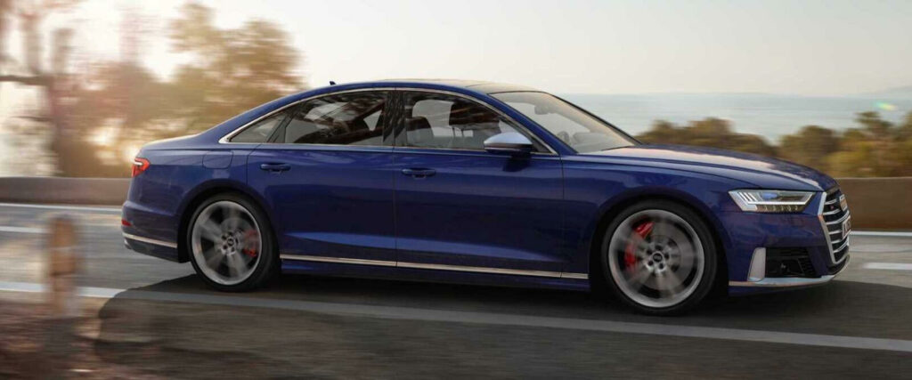 En Audi S6 sedan kör på en väg. (AI text)