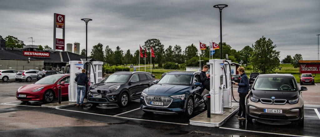 En grupp bilar parkerade vid en bensinstation. (AI text)