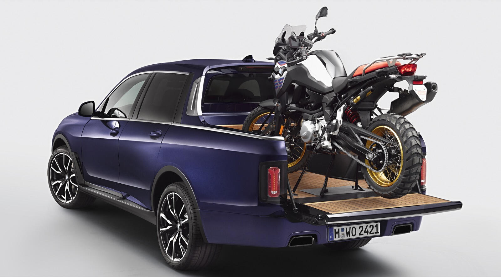 En blå plockare med en motorcykel i bakluckan. (AI text)