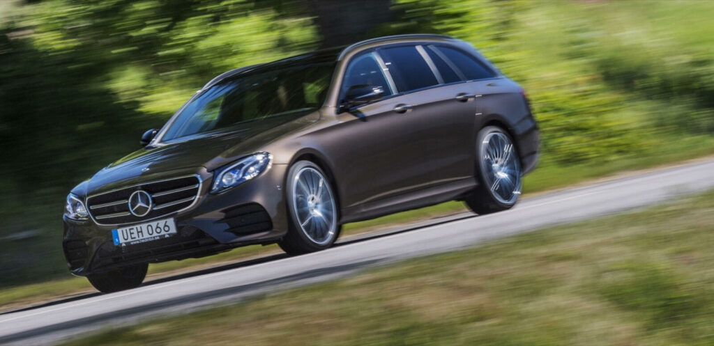 Mercedes-Benz E-klasstillverkningen kör längs en landsväg. (AI text)
