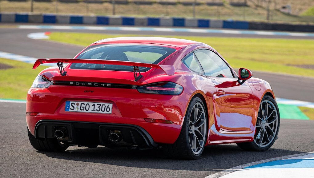 En röd Porsche Cayman GTS kör på en racebana. (AI text)
