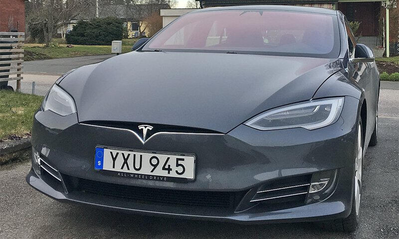 Tesla Model X parkerad framför ett hus. (AI text)