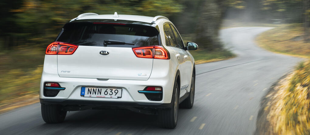 En vit terrängbil kör nerför en landsväg. (AI text)