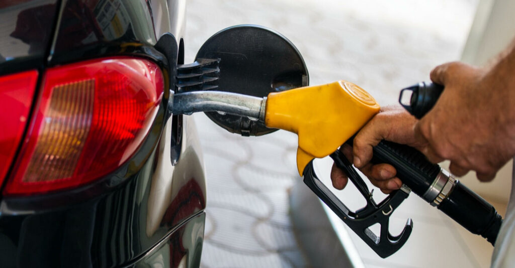 En man tankar sin bil med bränsle. (AI text)