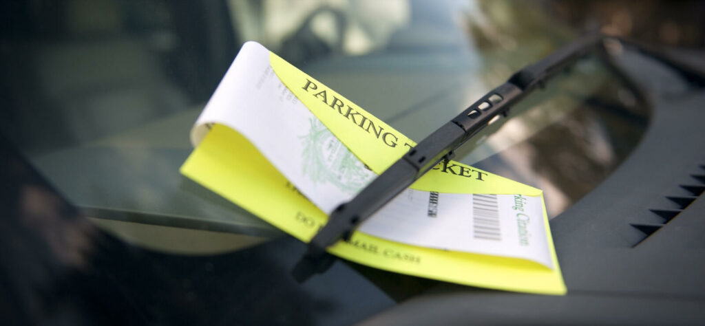 En parkeringsbot sitter på förarättens förgrening på en bil. (AI text)