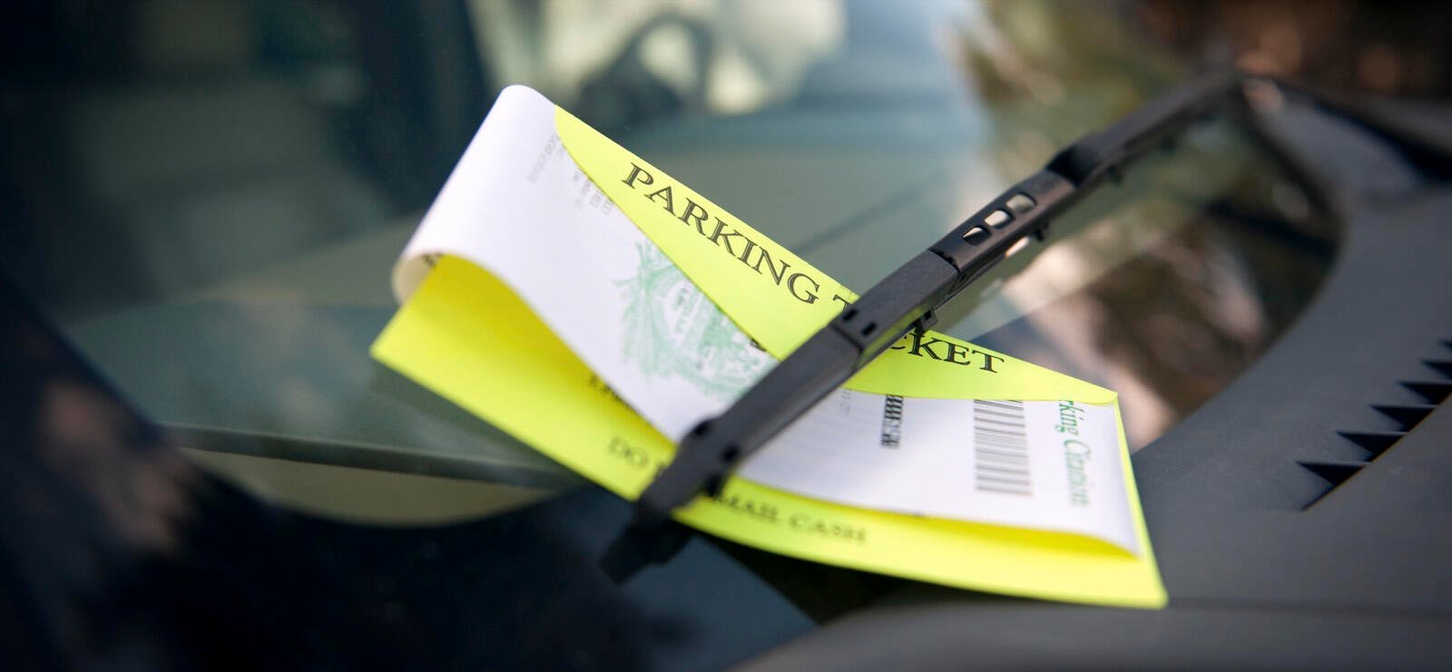 En parkeringsbot sitter på förarättens förgrening på en bil. (AI text)