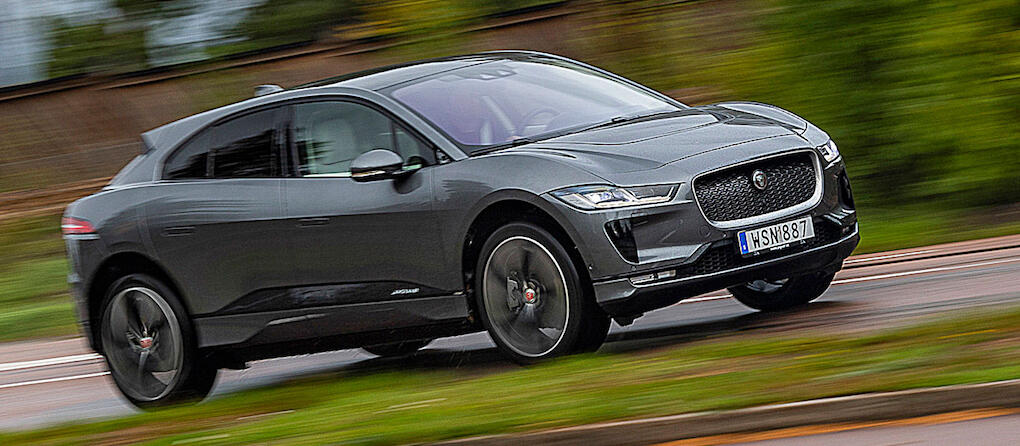 En Jaguar I Pace kör nedför en landsväg. (AI text)