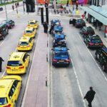 En stadsgata med många bilar och folk (AI text)