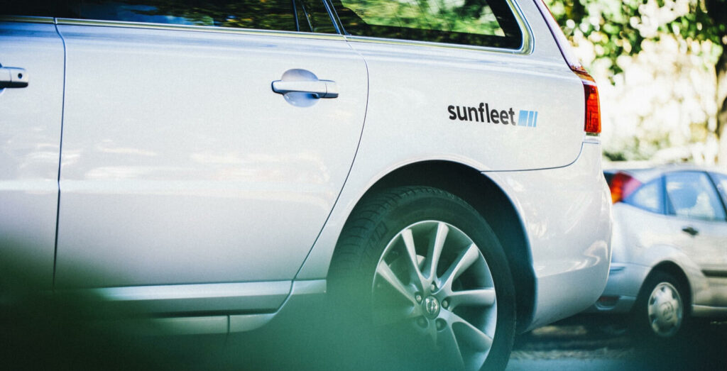 En vit bil parkerad i en parkeringsplats. (AI text)