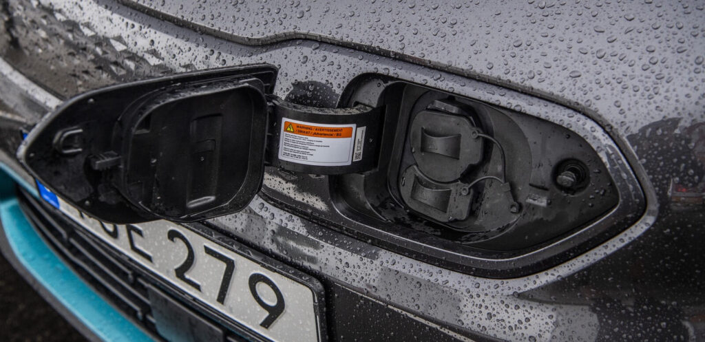 En bil står parkerad bredvid en laddstation. (AI text)