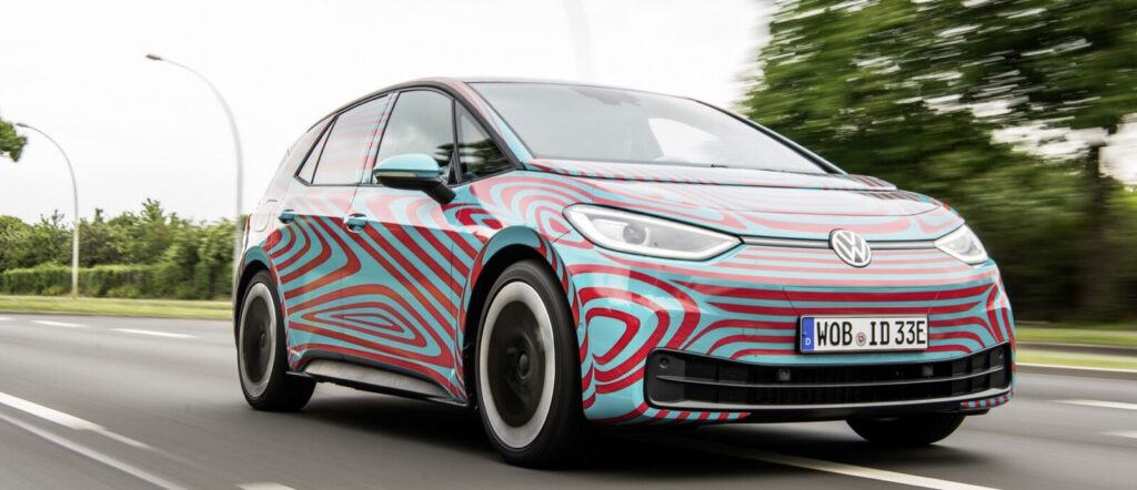 En Volkswagen I, en up! och en EV kör nedför en väg. (AI text)