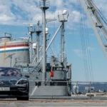 En bil parkerad vid en piersida. (AI text)