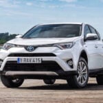 En vit Toyota RAV4 parkerad vid en kaj. (AI text)