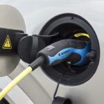 En bil är uppkopplad till en elladdare. (AI text)