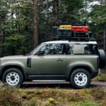 En Land Rover Defender kör genom skogen. (AI text)