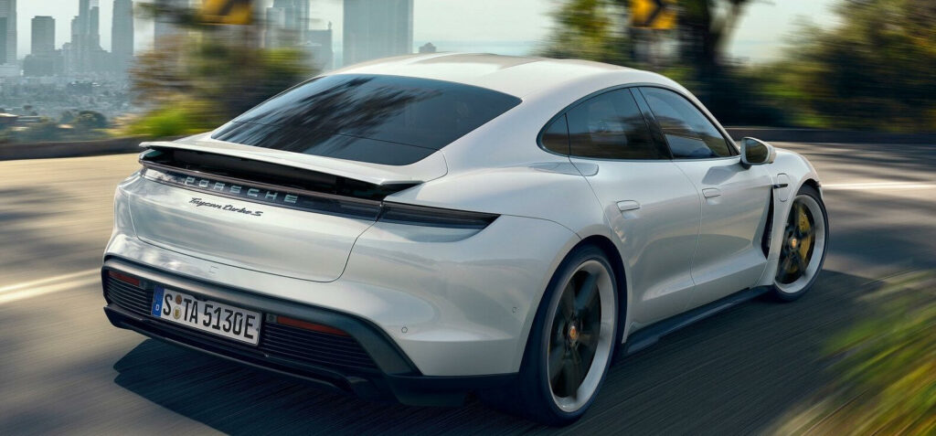 Den nya Porsche Cayman kör längs en stadsgata. (AI text)