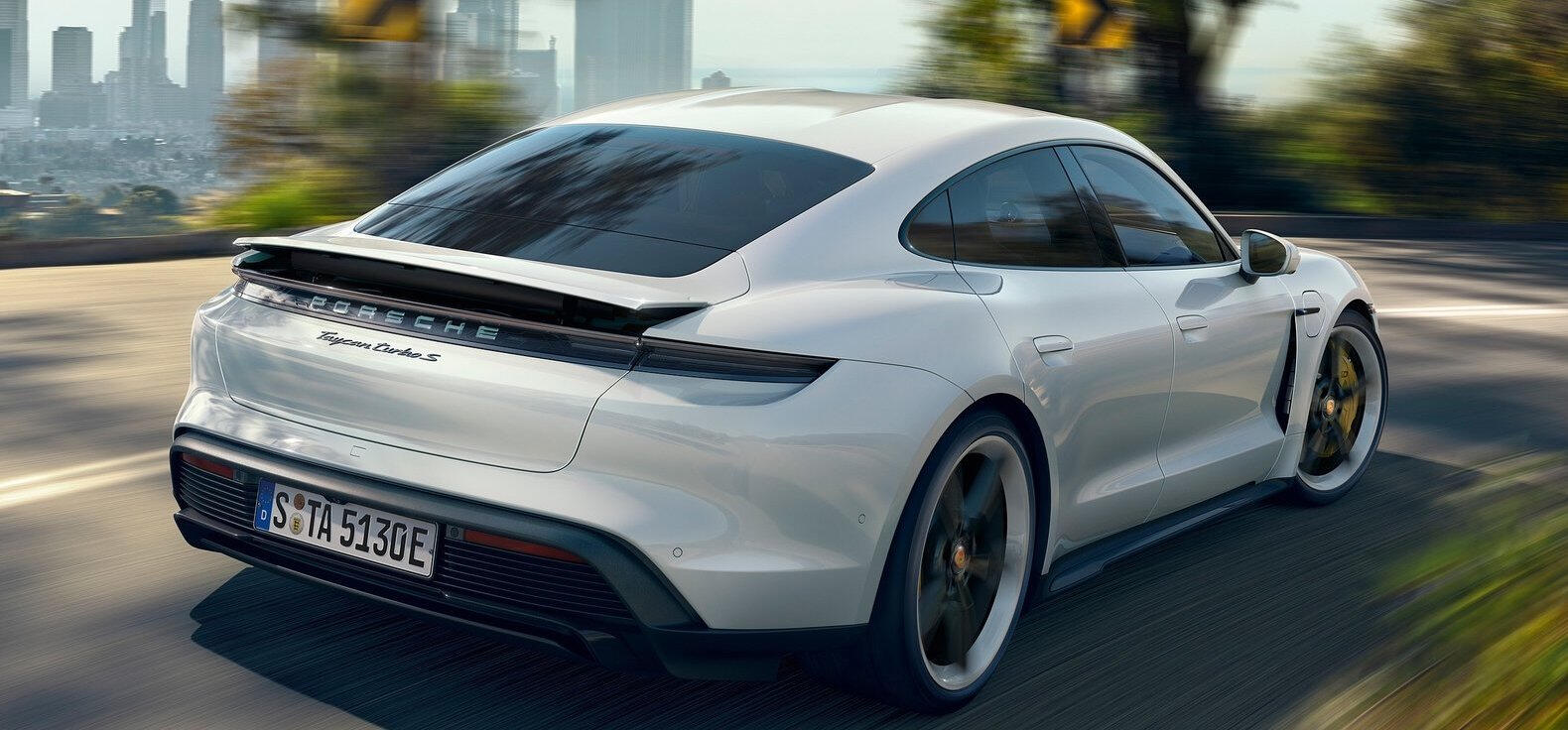 Den nya Porsche Cayman kör längs en stadsgata. (AI text)