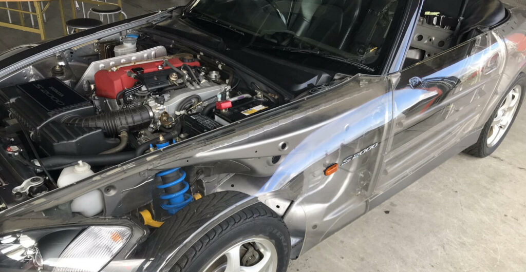 En silverfärgad sportbil med upphängd motor. (AI text)