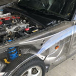 En silverfärgad sportbil med upphängd motor. (AI text)