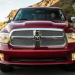 En röd lastbil från märket Ram kör nerför en bergsväg. (AI text)