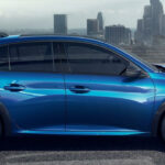 En blå Renault C3 parkerad framför en stad. (AI text)