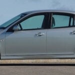 En silverfärgad bil parkerad vid en gata. (AI text)