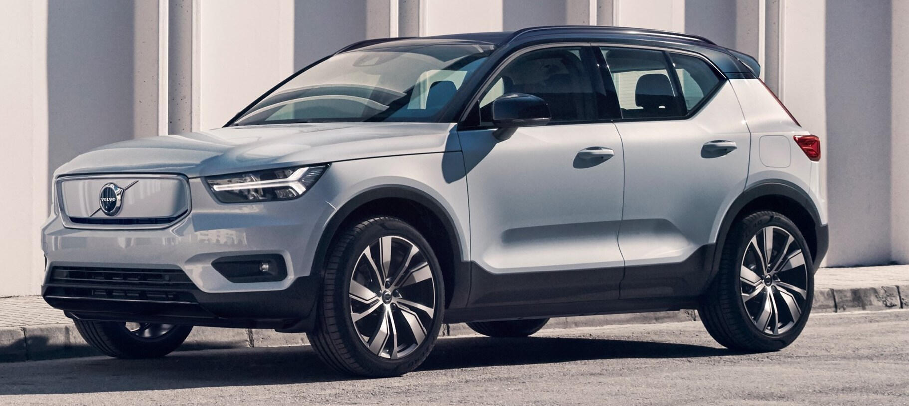 En Volvo XC90 SUV parkerad framför ett byggnad. (AI text)