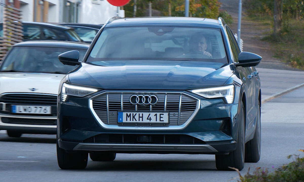 En Audi Q3 SUV kör ner en gata. (AI text)