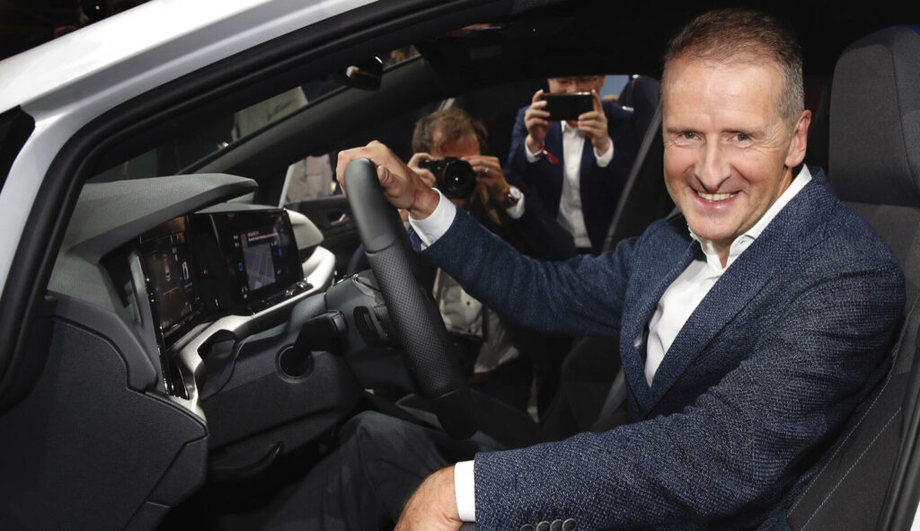 En man i kostym sitter i förarsätet i en bil. (AI text)