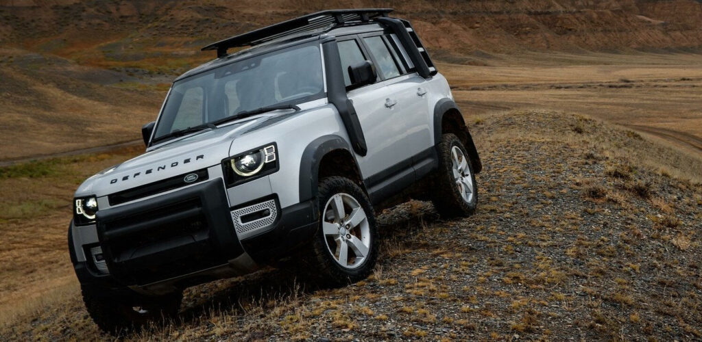 En Land Rover Defender kör nerför en backe. (AI text)