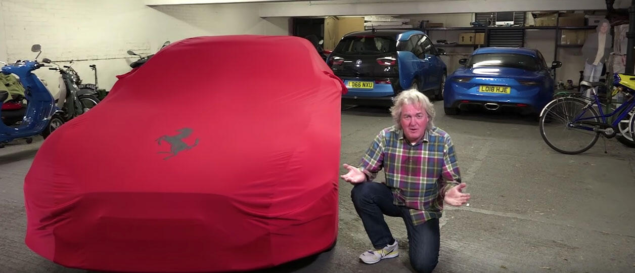 En man knegar bredvid en röd bil i en garage. (AI text)