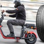 En man cyklar på en scoot med en däck. (AI text)