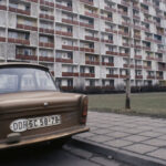 En bil parkerad framför ett byggnad. (AI text)