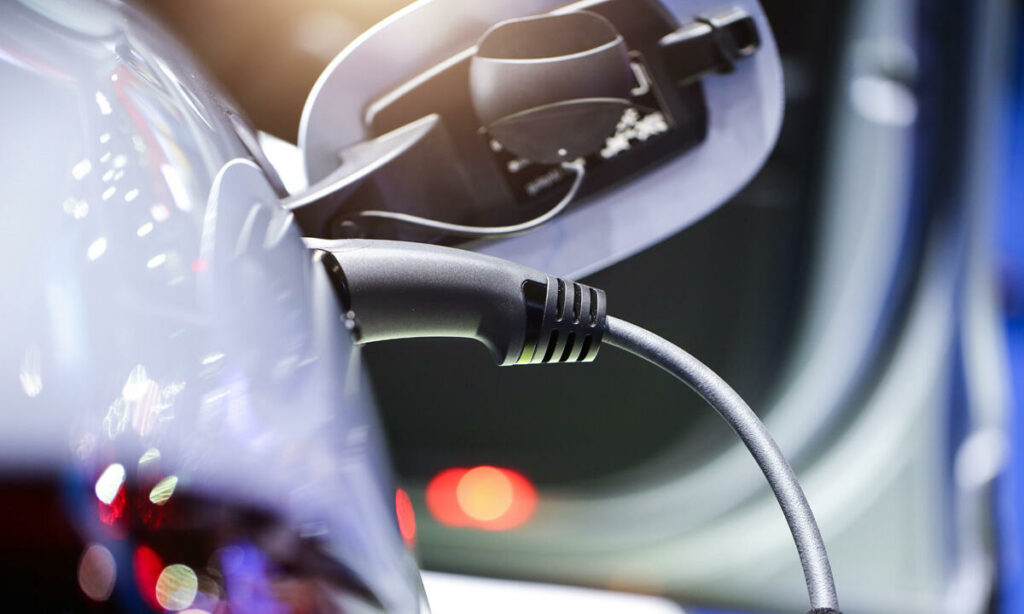 En bil är uppkopplad till en eluttag. (AI text)