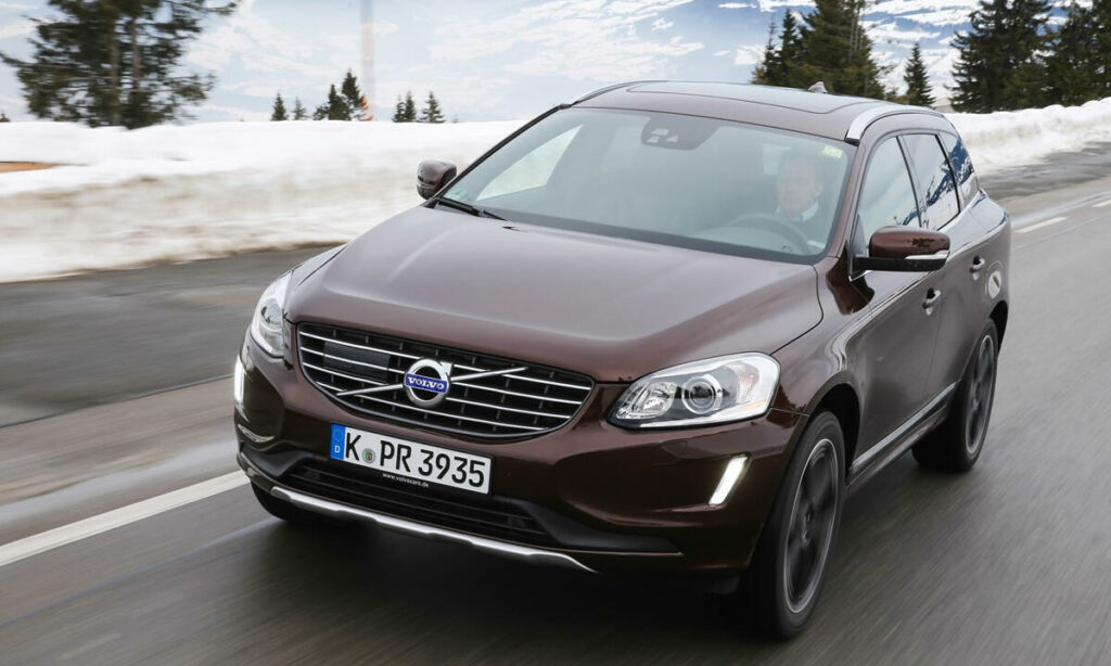 Volvo XC90 SUV kör nerför en snöig väg. (AI text)