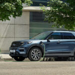 En man laddar sin elbil vid en laddstation. (AI text)