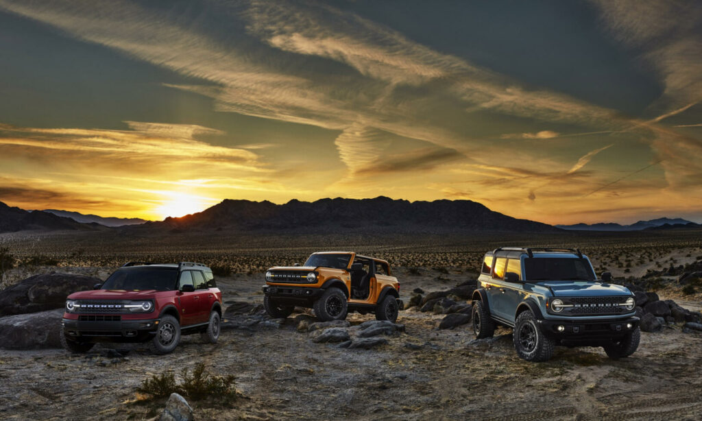 Fyra Ford Broncos parkerade i öknen vid solnedgången (AI text)