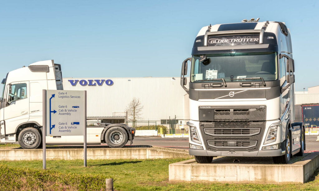 En Volvo-lastbil parkerad framför en fabrik. (AI text)