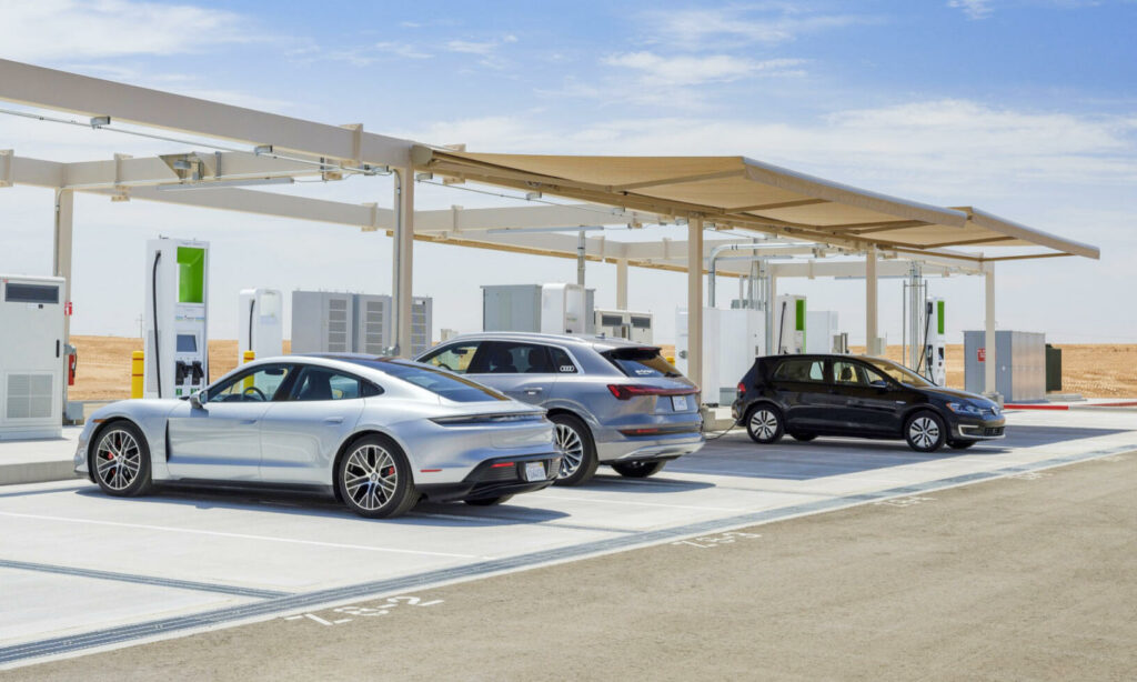 En bil står parkerad vid en elbilsladdstation i öknen. (AI text)