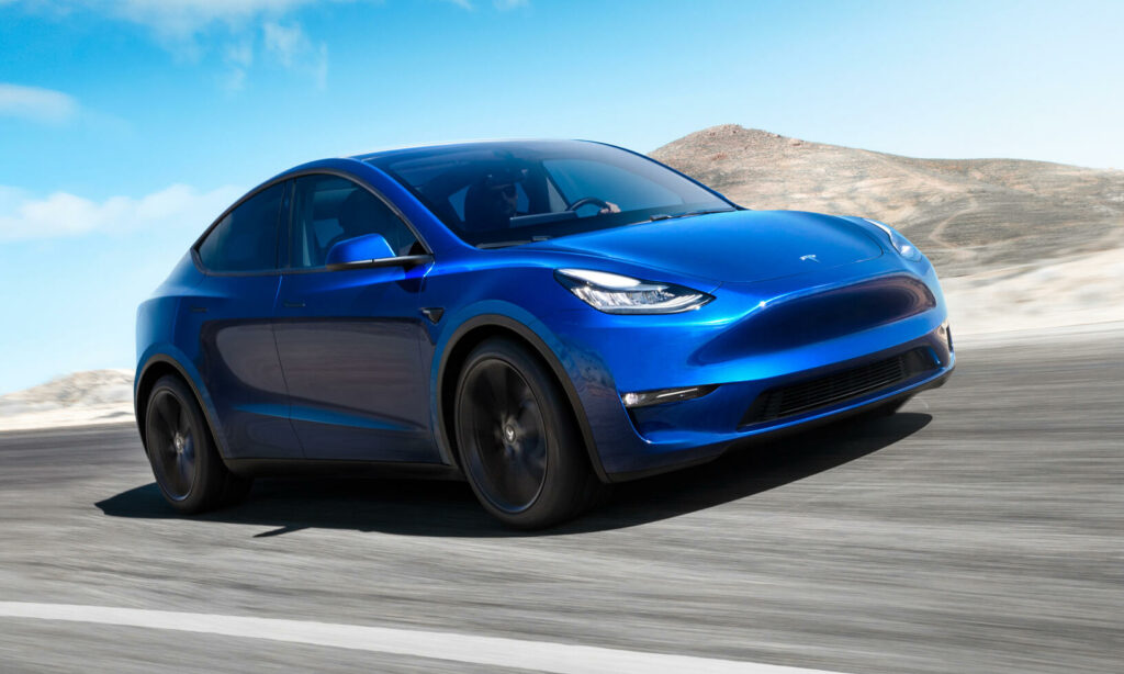 Tesla Model Y kör på en bergsväg. (AI text)