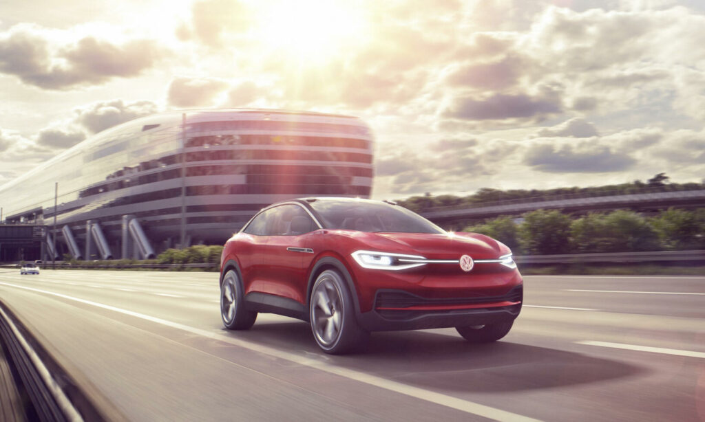 En röd Volkswagen T-Roc SUV kör längs en motorväg. (AI text)