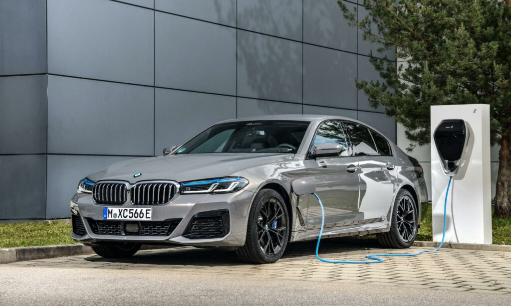 BMW I8 laddar elbil framför ett byggnad. (AI text)