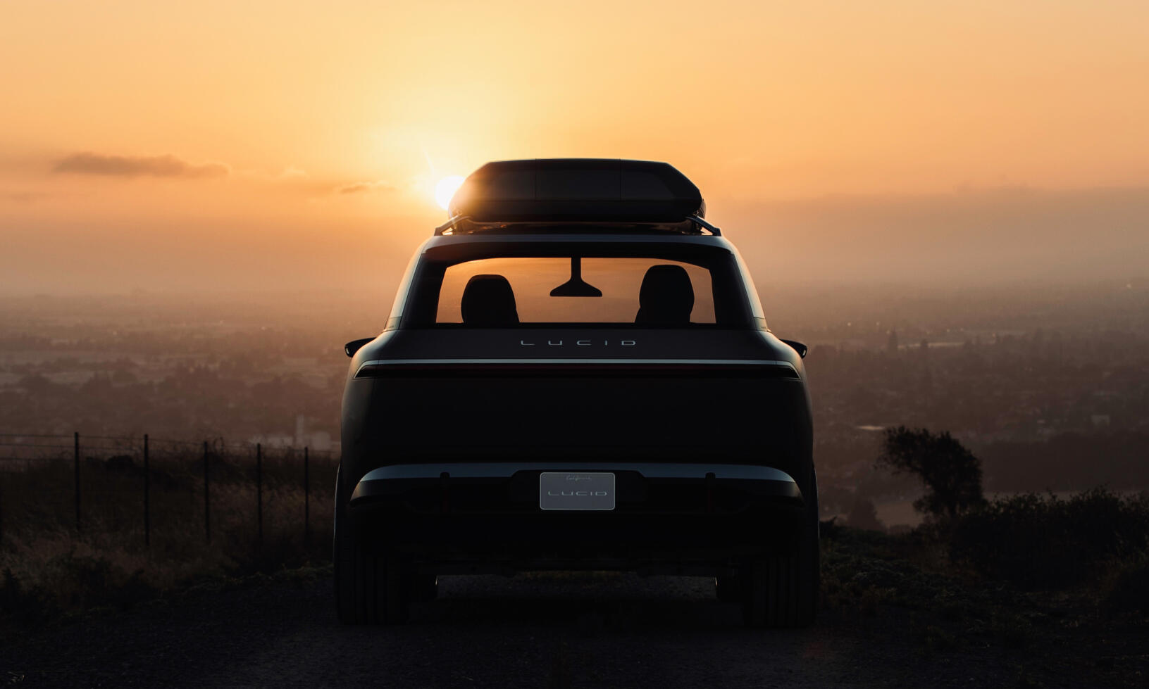 En bil kör nerför en stentrångad väg vid solnedgången. (AI text)