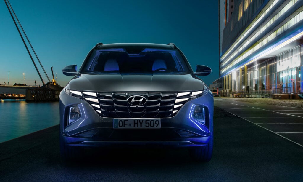 Hyundai Santa Fe står parkerad framför ett byggnad nattetid. (AI text)