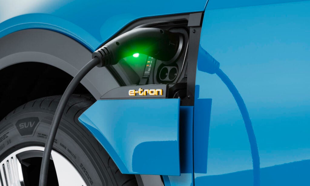 En blå bil är uppkopplad till en elladdare. (AI text)