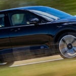 En svart Volvo XC90 kör nerför en landsväg. (AI text)