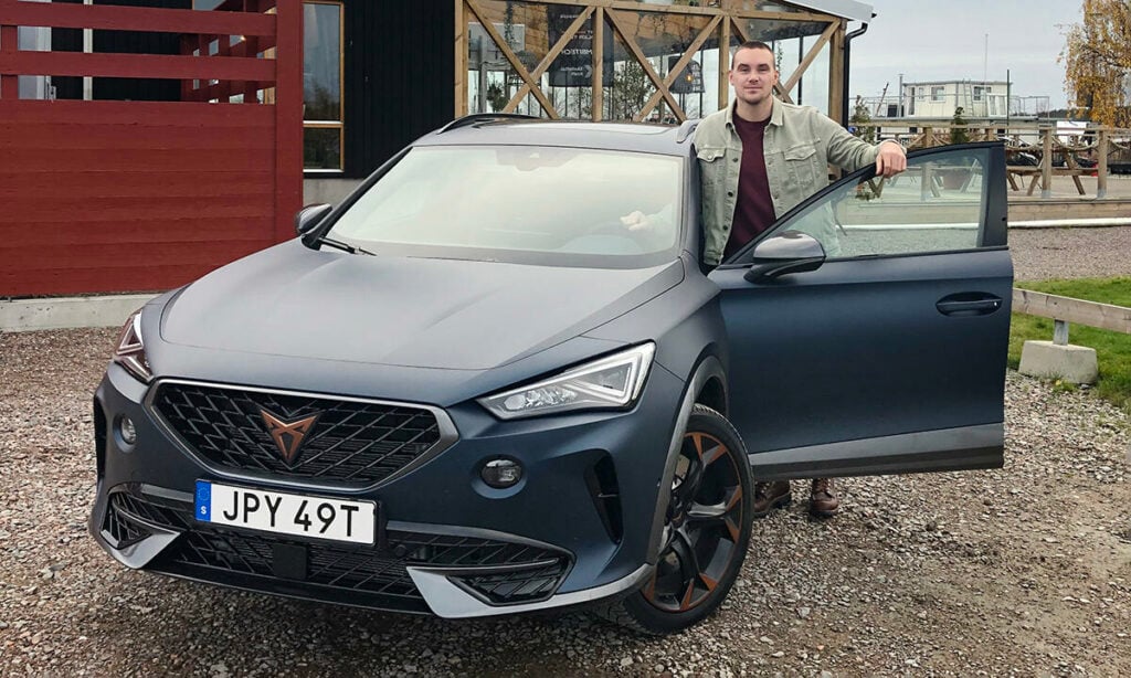 En man står bredvid en bil. (AI text)