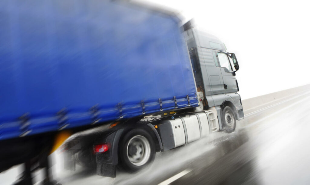 En lastbil kör nedför vägen. (AI text)