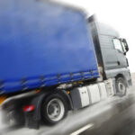 En lastbil kör nedför vägen. (AI text)