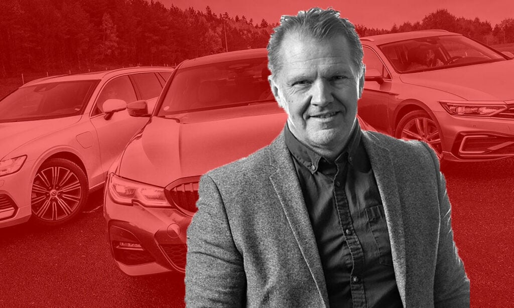 En man står framför en grupp bilar. (AI text)